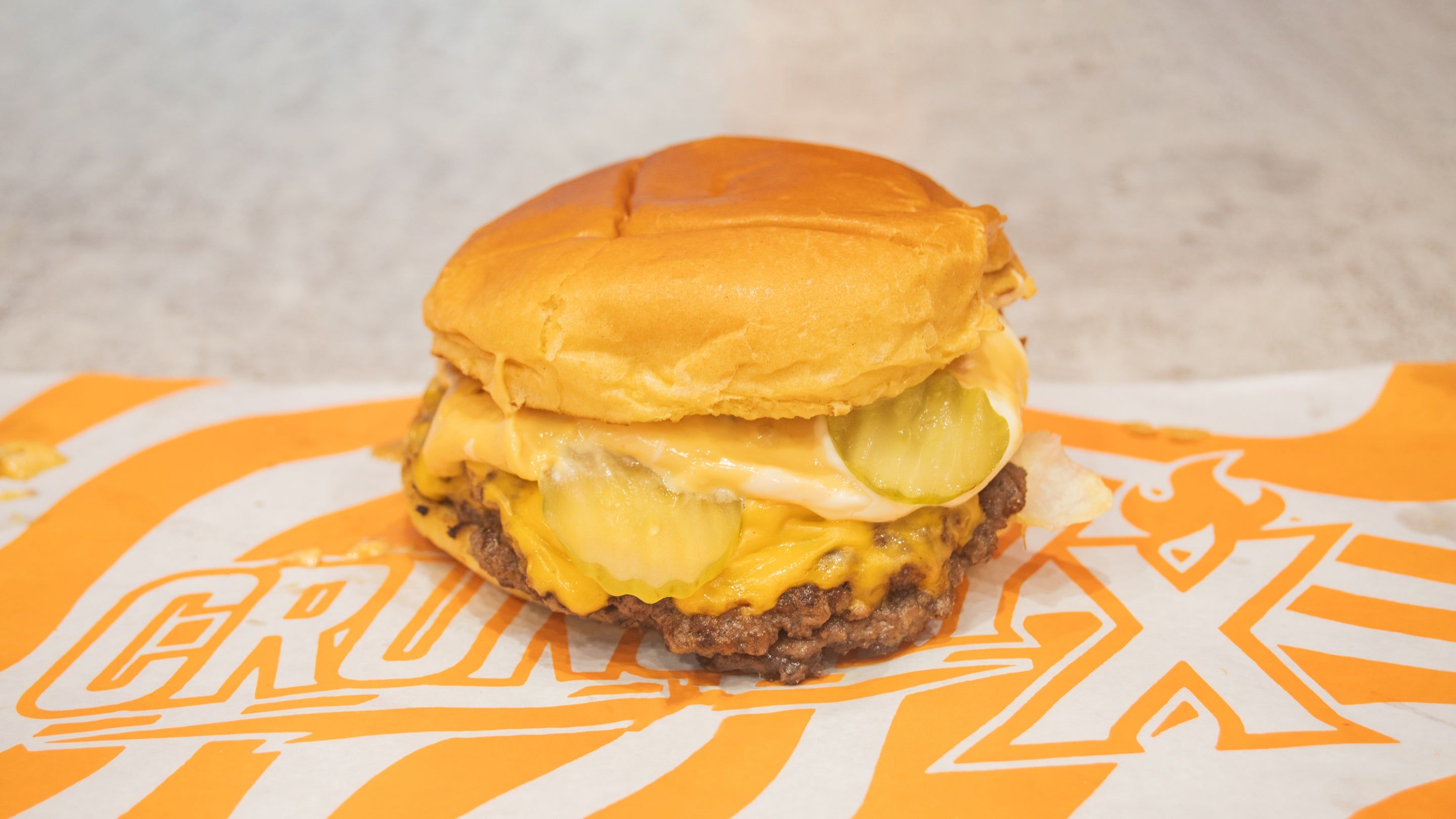 L'Original : smash burger steak, cheddar et cornichons sur le papier Crunchy X